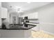 Bright kitchen features white cabinets, black countertops, stainless appliances, and an island with bar seating at 110 Ashworth Dr., Little River, SC 29566