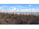 Seaside landscape of beach and ocean with a rustic fence, under a cloudy blue sky at 1105 S Ocean Blvd. # 250, Myrtle Beach, SC 29577