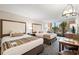 Cozy bedroom with two beds, a small work area, and a nice balcony view of the tropical vegetation at 1105 S Ocean Blvd. # 250, Myrtle Beach, SC 29577