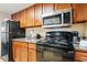 Kitchen featuring wood cabinets, granite countertops, and black appliances at 1105 S Ocean Blvd. # 250, Myrtle Beach, SC 29577
