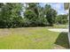 Spacious backyard features green lawn, mature trees, and a sleek black fence at 1178 Pyxie Moss Dr., Little River, SC 29566