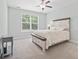 Serene bedroom with large window, soft carpet, ceiling fan, and neutral decor creating a relaxing atmosphere at 1178 Pyxie Moss Dr., Little River, SC 29566