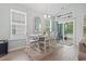 Light-filled dining room features a stylish table set, accent window, and sliding glass doors to patio at 1178 Pyxie Moss Dr., Little River, SC 29566
