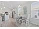 Open dining area with table set, window, and seamless flow into the modern white kitchen at 1178 Pyxie Moss Dr., Little River, SC 29566