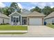 Charming single-story home featuring a stone accented garage, rocking chairs, and a well-manicured lawn at 1178 Pyxie Moss Dr., Little River, SC 29566