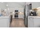 Modern kitchen with stainless steel appliances, white cabinets, quartz countertops, and light wood floors at 1178 Pyxie Moss Dr., Little River, SC 29566