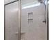 Close-up of a tiled walk-in shower with glass door and built-in niche for storage at 1178 Pyxie Moss Dr., Little River, SC 29566
