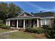 Charming brick home featuring a welcoming front porch with classic columns and manicured landscaping at 124 Orange St., Georgetown, SC 29440