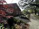 Landscaped side yard featuring an outdoor patio, seating, and brick facade at 124 Orange St., Georgetown, SC 29440