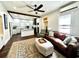 Open living room showcasing hardwood floors, ceiling fan, leather couch and seamless flow to kitchen at 124 Orange St., Georgetown, SC 29440