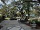 Charming stone patio with seating area, lush greenery and palm tree at 124 Orange St., Georgetown, SC 29440