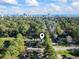 Aerial view of a house surrounded by trees, ocean, and city skyline in the distance at 1300 Ragin St., Myrtle Beach, SC 29577
