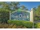 Welcome to River Oaks Golf Club! View of the golf club entrance sign surrounded by lush greenery and blooming flowers at 1302 River Oak Dr. # 4B, Myrtle Beach, SC 29579