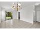 Bright living room with chandelier, tile flooring, and access to the outdoor patio at 1302 River Oak Dr. # 4B, Myrtle Beach, SC 29579