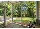 Relaxing screened porch overlooking a lush green space and mature trees, perfect for enjoying the outdoors at 1302 River Oak Dr. # 4B, Myrtle Beach, SC 29579