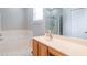 Bright bathroom featuring a soaking tub, vanity with a large mirror, and a glass-enclosed shower at 161 Patriot Ln., Pawleys Island, SC 29585