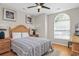 Cozy bedroom featuring a wooden bed frame, a ceiling fan with lights, and a large window at 161 Patriot Ln., Pawleys Island, SC 29585
