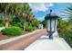 Picturesque entrance with brick drive, palm trees, lush landscaping, and a charming guardhouse at 161 Patriot Ln., Pawleys Island, SC 29585