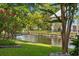 Landscaped backyard with mature trees, flowering shrubs, and serene water views at 17 Trigger Fish Ln., Murrells Inlet, SC 29576