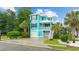 Charming two-story home with a vibrant turquoise exterior, a white roof, and a well-manicured lawn at 17 Trigger Fish Ln., Murrells Inlet, SC 29576