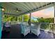 Covered porch with outdoor seating and view of a colorful sunset at 17 Trigger Fish Ln., Murrells Inlet, SC 29576