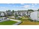 Aerial view of gray townhomes featuring a swimming pool, lush greenery, and residential buildings in a neighborhood at 1890 Colony Dr. # 17L, Surfside Beach, SC 29575