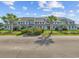 Charming condo complex with well-manicured landscaping and palm tree accents under a bright blue sky at 1890 Colony Dr. # 17L, Surfside Beach, SC 29575