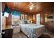 Bedroom with wood paneling, a white headboard bed, a white nightstand and ample natural light at 2006 S Ocean Blvd., North Myrtle Beach, SC 29582
