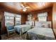 Charming bedroom with knotty pine walls, two beds, and lots of natural light at 2006 S Ocean Blvd., North Myrtle Beach, SC 29582
