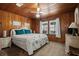 Cozy bedroom with wood-paneled walls, white wicker headboard and side table and bright windows at 2006 S Ocean Blvd., North Myrtle Beach, SC 29582