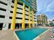 Exterior of building with a bright outdoor swimming pool under yellow umbrellas at 2301 S Ocean Blvd. # 1405, North Myrtle Beach, SC 29582