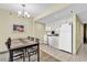Well-equipped kitchen with white cabinets and appliances next to a dining area for six at 2301 S Ocean Blvd. # 1405, North Myrtle Beach, SC 29582