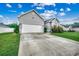 Home featuring a large driveway leading to an attached two-car garage with well-maintained lawn at 2461 Summerhaven Loop, Conway, SC 29527