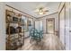 Cozy dining area featuring a glass-top table, four chairs, and a decorative shelving unit near the window at 259 Iroquis Trail, Longs, SC 29568