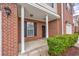 Inviting covered front porch with classic brick facade, white columns, and manicured greenery at 265 Connemara Dr. # D, Myrtle Beach, SC 29579