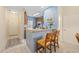 Compact kitchenette with wood cabinets, breakfast bar, and view into hallway and entrance at 265 Connemara Dr. # D, Myrtle Beach, SC 29579