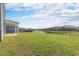 Large fenced backyard featuring green lawn and view of community pond at 2989 Skylar Dr., Myrtle Beach, SC 29577