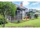 Backyard view showcasing a two-story home with an attached screened-in porch and spiral staircase at 302 Sunnehanna Dr., Myrtle Beach, SC 29588