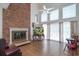 Cozy living room with a brick fireplace, hardwood floors, and large windows with floral curtains at 302 Sunnehanna Dr., Myrtle Beach, SC 29588