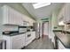 Traditional kitchen features white cabinetry, stainless steel appliances, and tiled floors at 303 Ayrie Ct., Conway, SC 29527