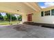 Carport with a red door, beige siding, and green shuttered windows at 308 Old Stage Rd., Mullins, SC 29574