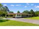 Ranch-style home with a carport, green shutters, and a well-manicured lawn at 308 Old Stage Rd., Mullins, SC 29574