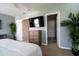 Bedroom with a television, wood dresser, and decorative plants creating a cozy and inviting space at 318 Castle Dr. # 1443, Myrtle Beach, SC 29579