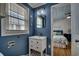 Nautical themed bathroom with blue walls, a white vanity, modern fixtures, and an adjacent bedroom at 321 53Rd Ave. N, North Myrtle Beach, SC 29582