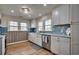Bright kitchen with white cabinets, tile backsplash, modern appliances, and a stainless steel sink near two windows at 321 53Rd Ave. N, North Myrtle Beach, SC 29582