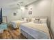 Charming bedroom featuring two queen beds, coastal decor, ceiling fan and light, and wood flooring at 323 Wendover Ct. # 10-A, Myrtle Beach, SC 29572