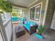 Cozy porch with wicker furniture, a swing, and views of green foliage at 323 Wendover Ct. # 10-A, Myrtle Beach, SC 29572