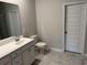 Modern bathroom featuring a white vanity, marble floors, toilet, and door to the shower at 3333 Sw Wood Stork Dr., Ocean Isle Beach, NC 28469