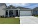 Charming single-story home with a two-car garage, manicured lawn, and inviting entrance at 3333 Sw Wood Stork Dr., Ocean Isle Beach, NC 28469