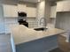 Modern kitchen featuring white cabinets, stainless steel appliances, and a quartz island at 3333 Sw Wood Stork Dr., Ocean Isle Beach, NC 28469
